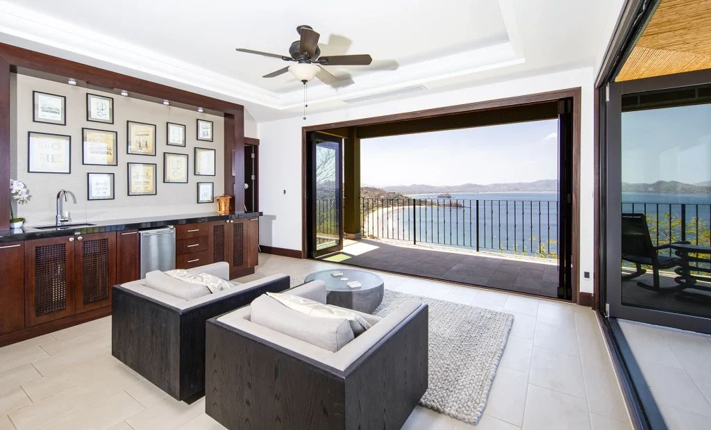 Living area at 360 Splendor with glass walls opening onto the terrace and bay.