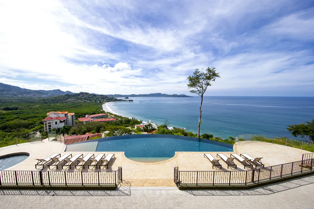 The infinity pool and terrace at 360 Splendor with sweeping coastline views.