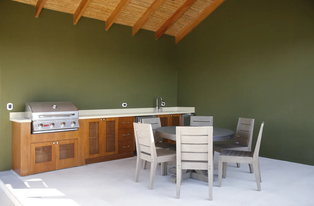 Rooftop outdoor kitchen and dining area at 360 Splendor with a grill and seating.